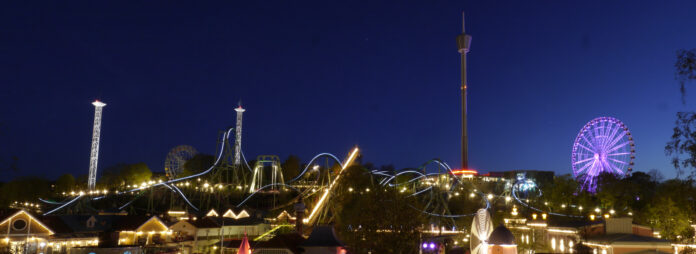 Liseberg upplyst i kvällsmörker med berg- och dalbanan Helix